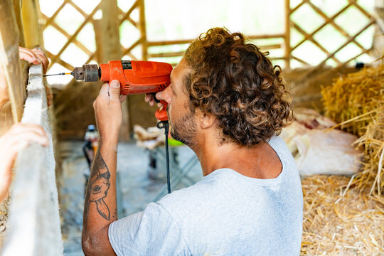 Worker drilling wooden frame in natural building project