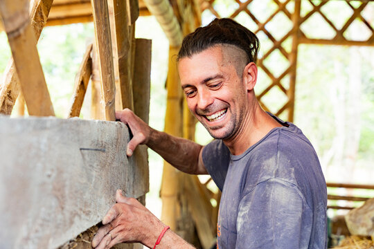 Smiling builder installing natural wall panel