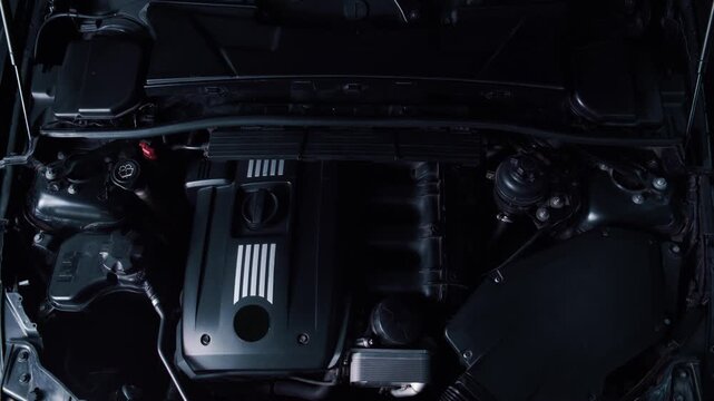 Opening the hood of the car and demonstrating the stylish dark underhood space and naturally aspirated engine of a famous brand
