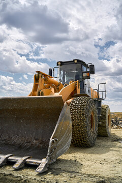 Industrial loader in open-pit copper mine under clouds