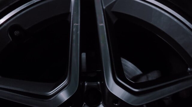 Macro shot footage of a beautifully rotating car wheel on chrome forged rims.