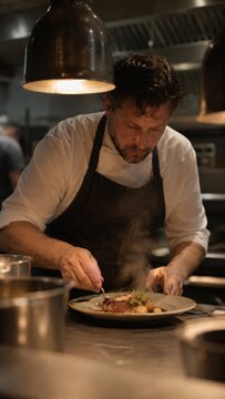 Professional chef carefully plating a gourmet dish with tweezers in a dimly lit restaurant kitchen, culinary craftsmanship concept photography concept
