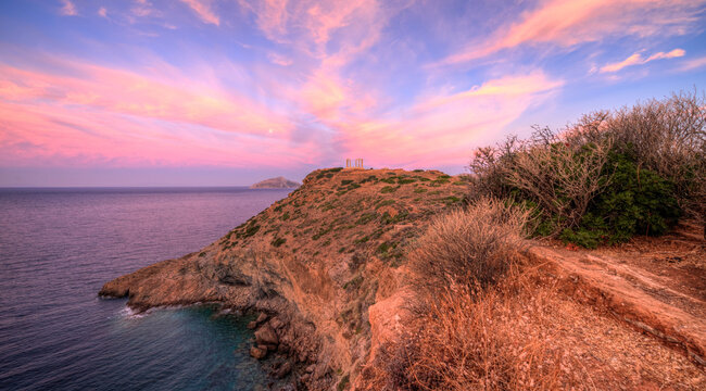 Pink sunrise over Poseidon's temple on the edge of the Aegean, Cape Sunio, Attica, Greece