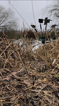 Vertical video of watermill wheel spinning on river bank during light rain and overcast autumn day