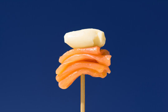 Smoked salmon slice with butter on cocktail skewer
