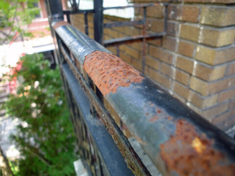 Garde-corps ext&eacute;rieur en m&eacute;tal rouill&eacute; sur un balcon.
