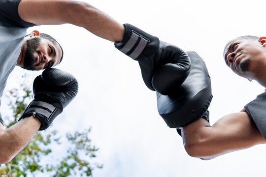 Friends practice boxing outdoors with focus and energy