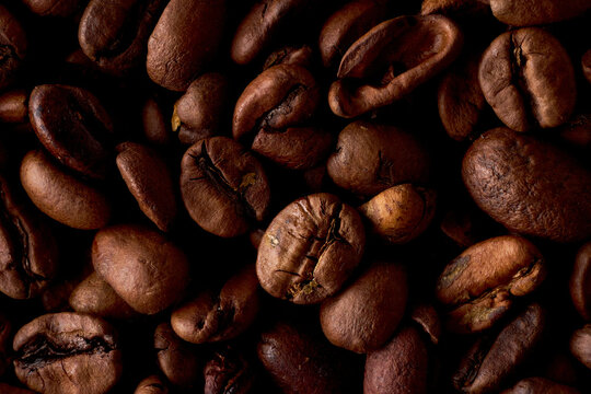 Macro closeup of roasted coffee beans texture on black