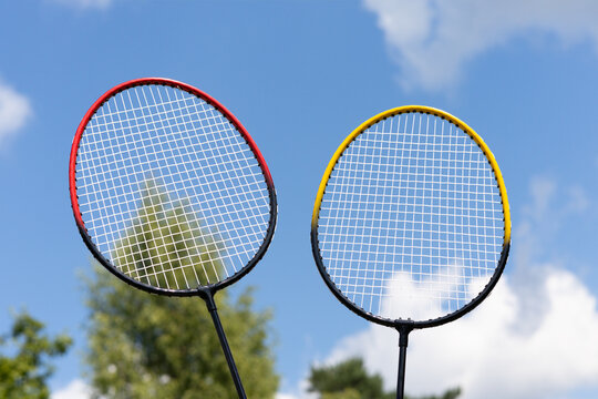 Badminton rackets against blue sky with clouds outdoors