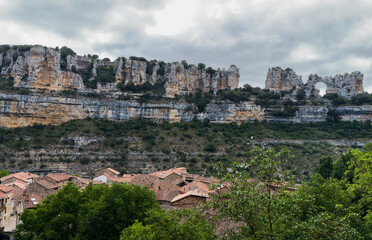 Fototapeta premium serene rock formations with red roofs in a rural landscape viewed from a high angle, featuring stone and brick materials under natural light, travel and real estate photography.