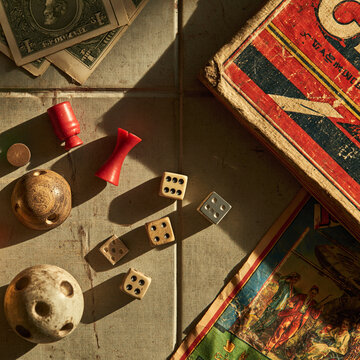 Vintage wooden dice and game pieces with old money for a retro board game night nostalgia math fun