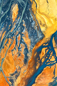 Abstract aerial river delta texture in vivid blue and gold