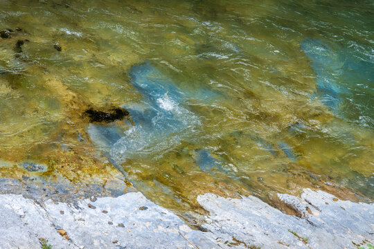 Flowing river water over rocky streambed nature background