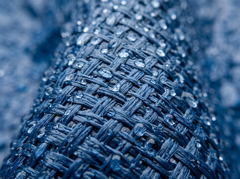 macro water droplets on blue woven fabric | waterproof synthetic material texture close up | blue heavy duty tarp with rain drops | durable industrial mesh textile background