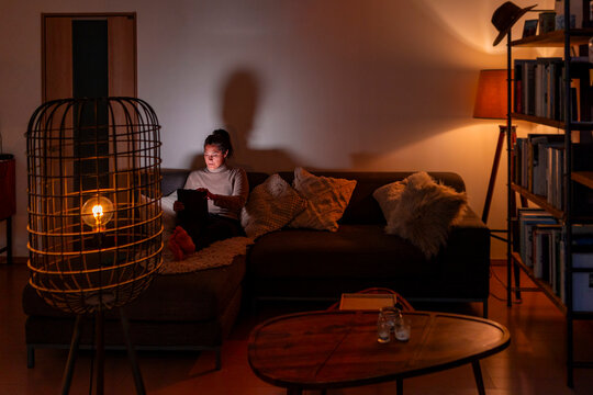 Woman working on tablet in cozy living room