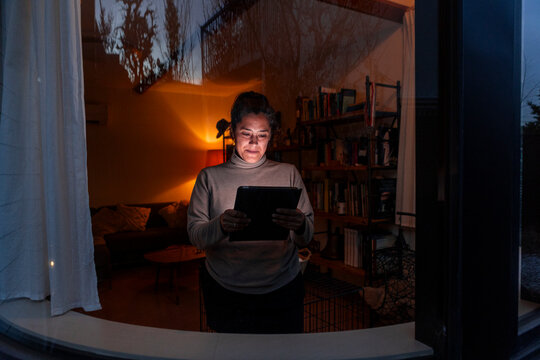 Woman using tablet while working in the evening