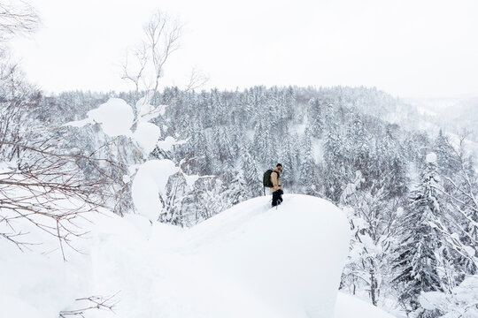Skier standing on deep powder snow ridge in Hokkaido