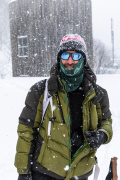 Ski touring skier in heavy snowfall with avalanche safety gear