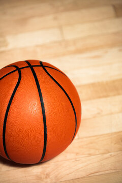 Basketball on polished indoor court floor