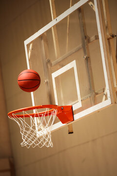 Basketball hoop with ball nearing the net indoors