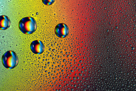 Colorful close-up of neon droplets on a vibrant surface