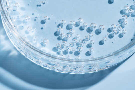 Close-up of sparkling water bubbles in glass on blue