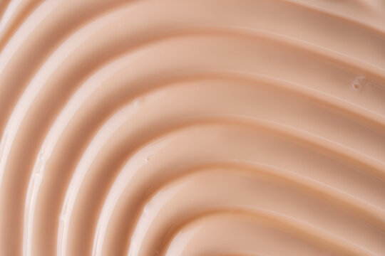 Beige body cream texture background with smooth swirl