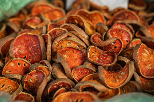 Dried bael fruit at a vibrant thai market stall