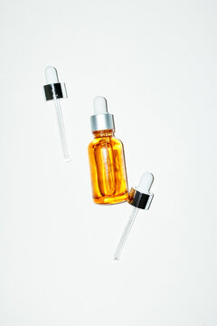 Minimal skincare serum bottle with droppers on white
