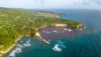 Aerial view of Cabo Frances Viejo, featuring lush green cliffs, dense vegetation, and turquoise waters meeting the Atlantic Ocean in Cabrera, Maria Trinidad Sanchez, Dominican Republic. © robert