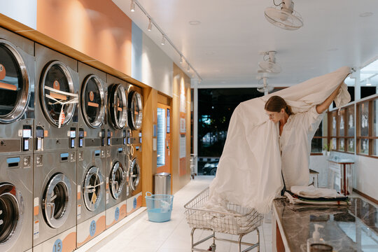Woman doing laundry in a self-service laundromat