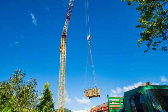 Caslano- Switzerland- 12 May 2026: construction crane lifting load against sky