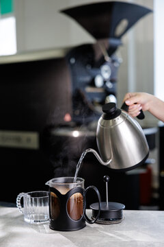 Fresh french press coffee being poured with hot water for cafe menu, beverage preparation scene