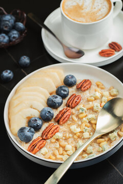 Oatmeal. Bowl of oatmeal porridge with blackberry, bananas and chia seeds on gray concrete old table background. Top view in flat lay style. Natural ingredients. Hot healthy breakfast and diet food