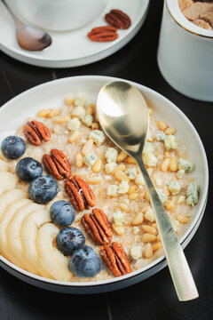 Oatmeal. Bowl of oatmeal porridge with blackberry, bananas and chia seeds on gray concrete old table background. Top view in flat lay style. Natural ingredients. Hot healthy breakfast and diet food