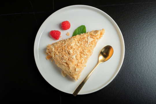 Sliced Napoleon cake on a white wooden table. Classic dessert