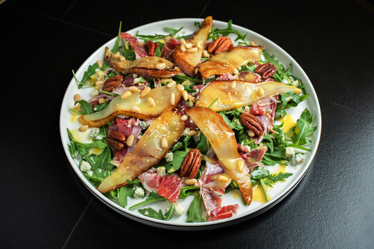 Salad with Pear, Arugula, Jamon, Blue Cheese and Blueberry, Delicious Fresh Salad Appetizer on Bright Background
