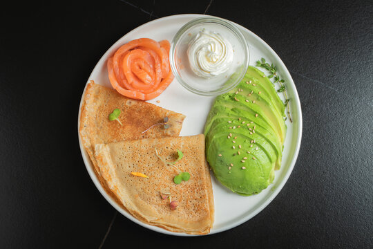 Roasted thin pancakes with smoked salmon and sauce