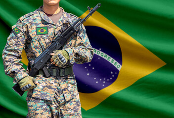 Fototapeta premium Brazil flag with soldier holding assault rifle