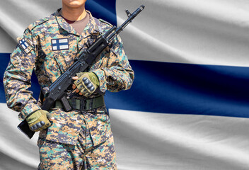 Fototapeta premium Finland flag with soldier holding assault rifle