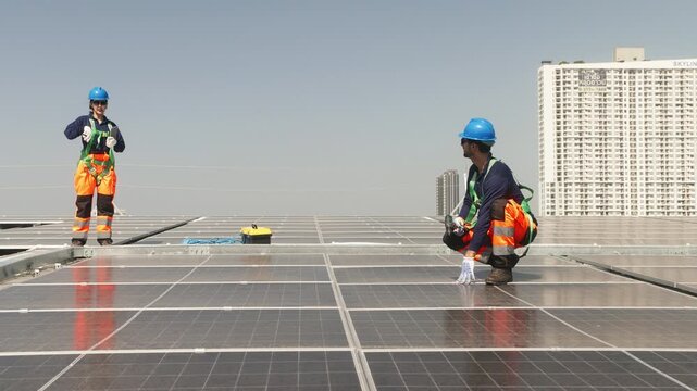 Two solar technicians inspecting rooftop photovoltaic panels, one adjusting panel alignment while colleague points and checks installation details.