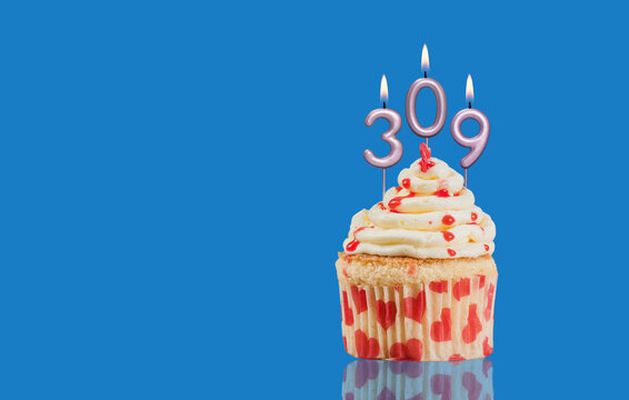 Birthday Or Anniversary Cupcake With Lit Candles; Candles Forming The Number 309