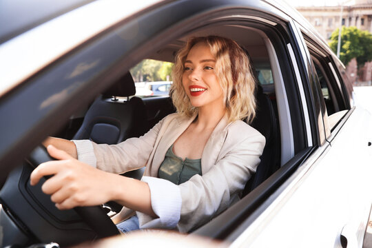 Woman driving modern car, view from outside