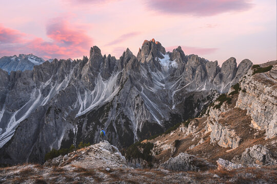Cadini di Misurina illuminated by soft sunrise colors above rugged alpine terrain in the Dolomites. Dramatic mountain landscape with jagged limestone peaks and fresh snow