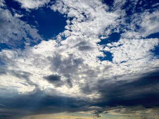 Fototapeta premium Beautiful blue sky with rays of sunlight shining through clouds