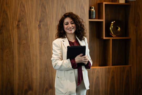 Professional woman holding tablet smiling in office