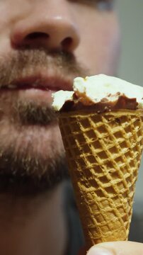 Close-up of a man enjoying an ice cream cone to cool down on a hot summer day, symbolizing refreshment, heatwave relief, and summer lifestyle.
