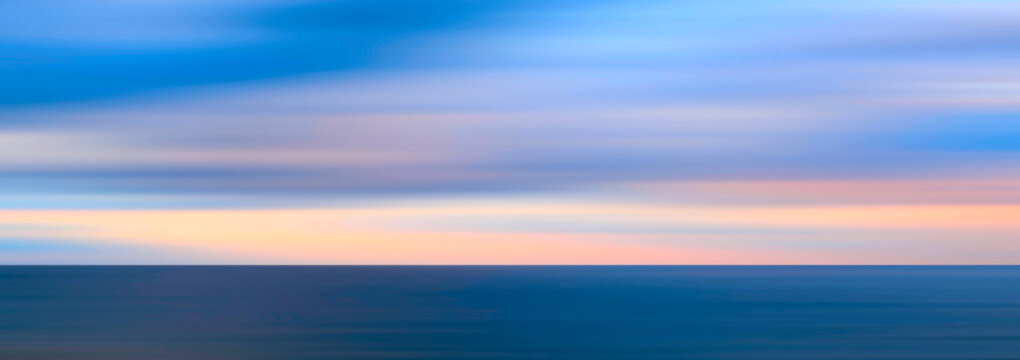 Delicate pastel pink meets a soft blue sky. Horizontal gradients transition into calming hues. Motion blur creates a peaceful atmosphere.