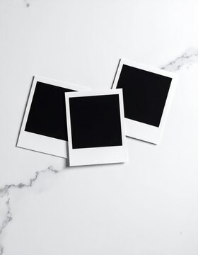 Three blank instant photo frames on a marbled surface