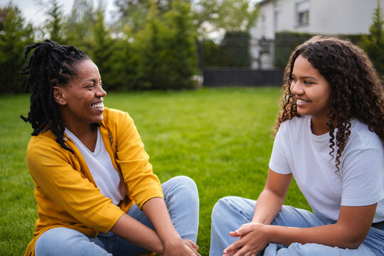 Mother and daughter laughing enjoying conversation outdoors